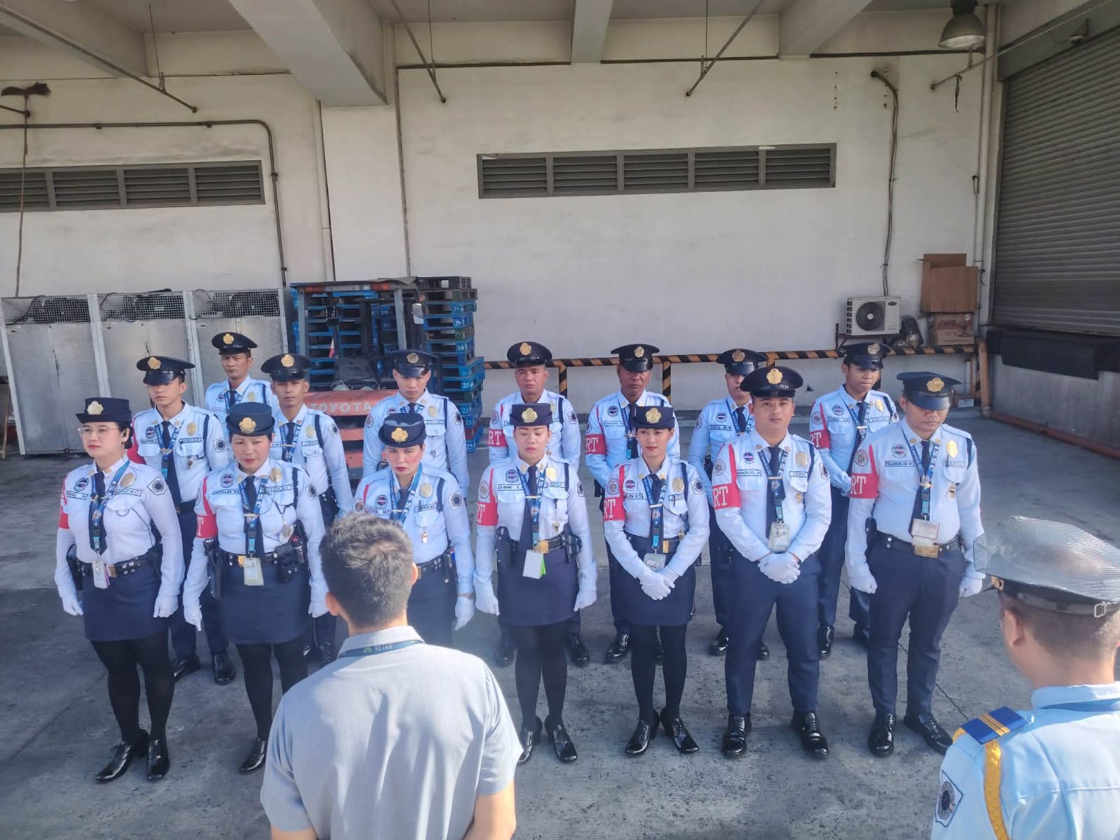 Jericko guards lined up for inspection in a warehouse loading area